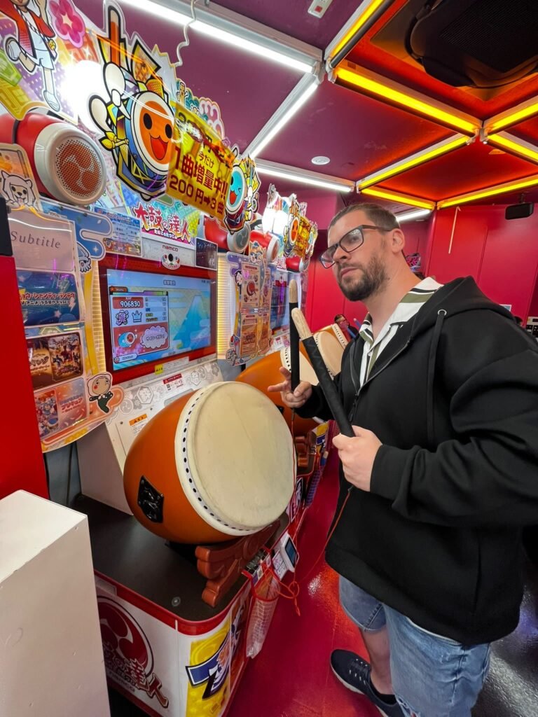 Jugador en una máquina recreativa arcade de ritmo musical en Taito Station Akihabara