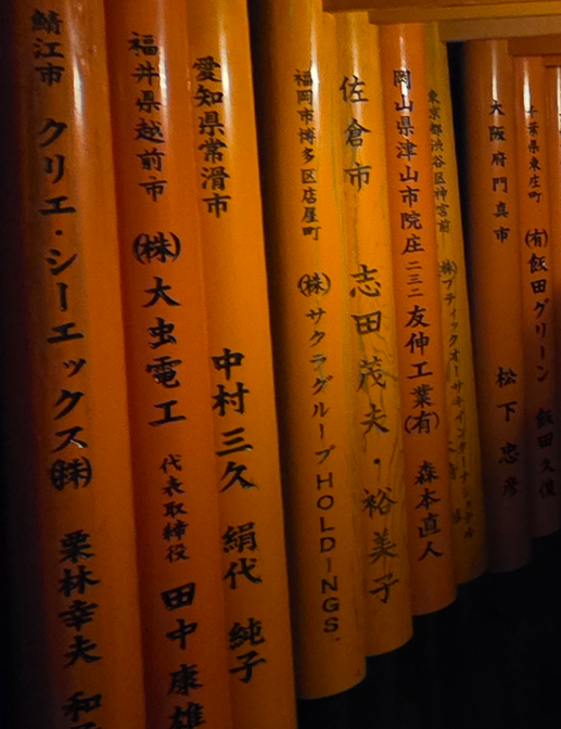 Guía Fushimi Inari Taisha 2026: El Santuario de las Mil Puertas Torii Inscripciones japonesas con nombres de empresas donantes en los torii de Fushimi Inari